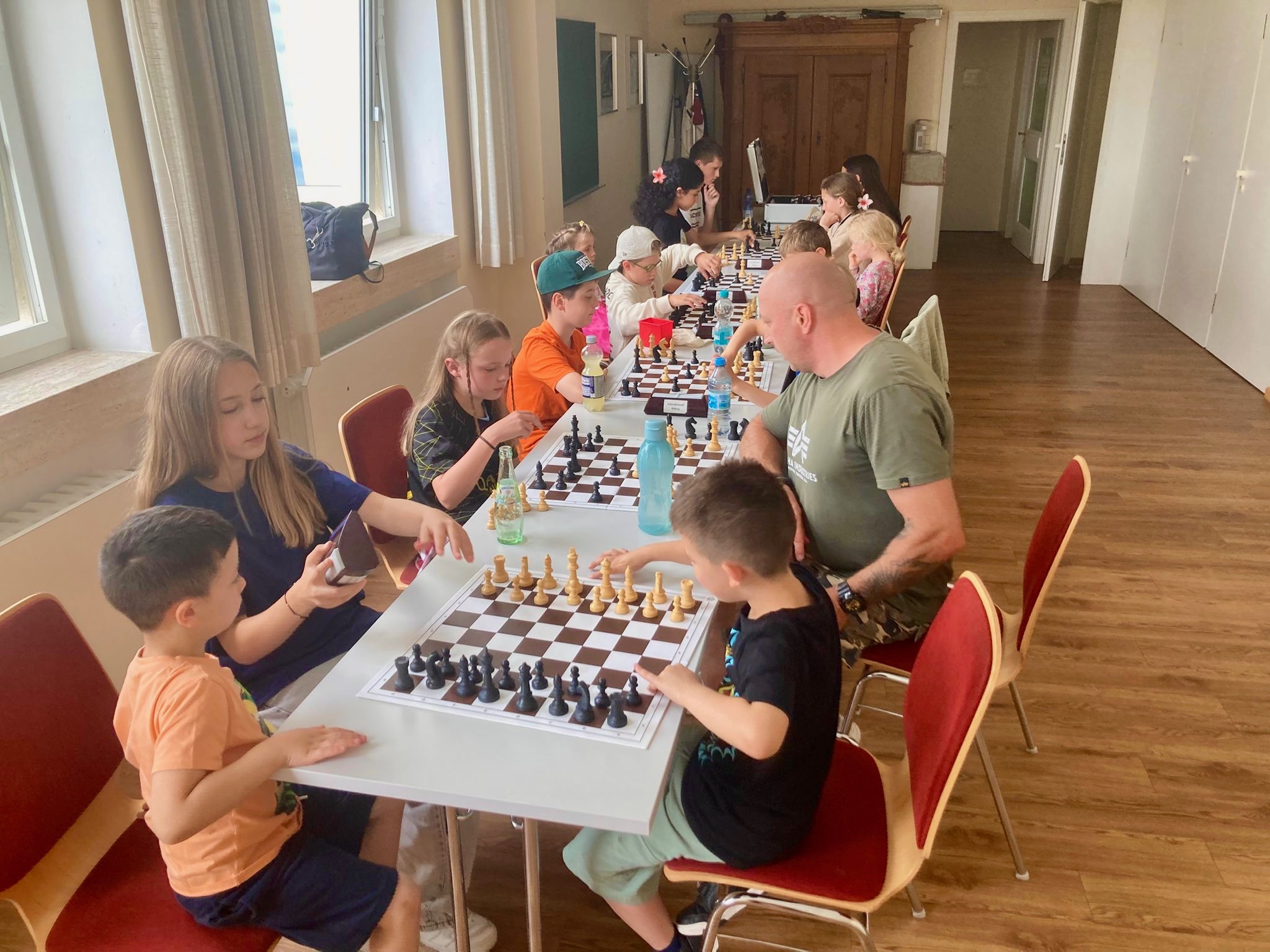 Unsere Jugendspielerin und Jugendtrainerin Maria Cucorada (2. v. l.) und Petru-Aurelian Cucorada (r.) mit unseren Kindern und Jugendlichen beim Schachtraining.